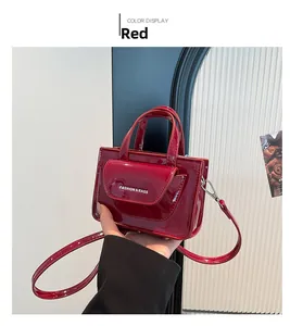 Detail of red glossy PU leather shoulder bag with chain strap and text print