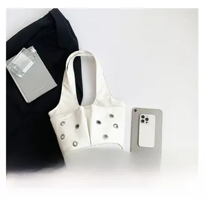 Détail du sac à bandoulière blanc avec œillets métalliques argentés et doubles poches