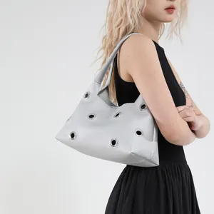 Silver metallic shoulder bag with large metal grommets and textured leather for women