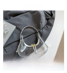 Vue détaillée du sac demi-lune en PVC transparent avec bordure argentée et zips dorés