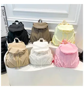 Muestra grupal de seis mochilas de nailon coloridas con cierre de cordón y bolsillos laterales