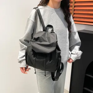 Mochila negra plisada minimalista de nailon ligero con cordón y correas anchas para hombros