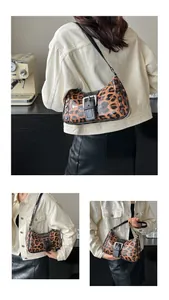 Detail showing the leopard print patent leather texture with rivet studs on the shoulder bag