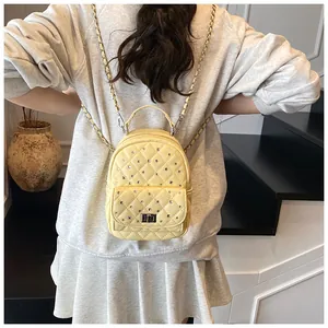 Dettaglio mini zaino trapuntato giallo pallido con strass e chiusura a girello in metallo