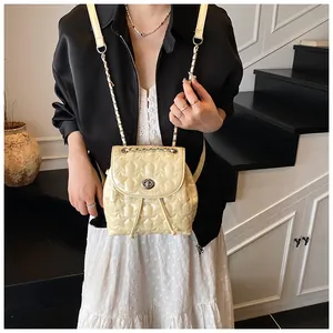 Dettaglio zaino beige trapuntato a stella con chiusura a scatto e catenella
