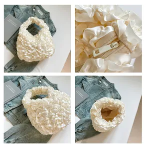 Detail of creamy ruffle handbag showing pearl satin texture and zipper inner pocket
