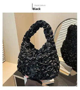 Detail of black ruffled handbag featuring tiered lace layers and soft silk-like texture