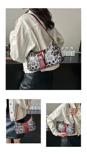 Detail of retro leopard print handbag with crimson straps and silver rivet accents