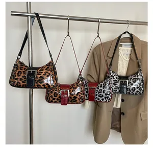 Detailed close-up of leopard print hobo bags with vintage studs and shiny metal buckle