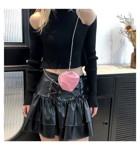 Detail of pink shell-shaped mini bag with white stitching and silver metal chain strap