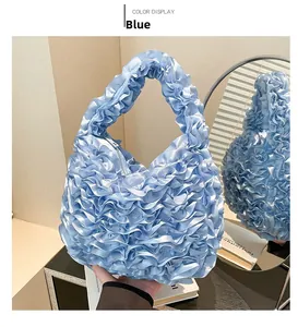 Detailed close-up of blue ruffle handbag with soft satin texture and cloud-like pleats