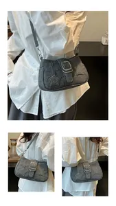 Detailed view of gray denim shoulder bag with rhinestone stars and silver metal buckle