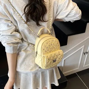 Mini zaino giallo trapuntato con catena e strass mostrato indossato da una modella