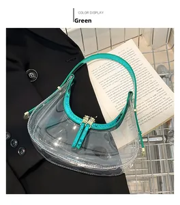Gros plan du sac en PVC translucide vert avec bordure en cuir verni dans un panier métal