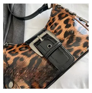 Detail view of leopard print underarm bag with silver rivets and metal buckle accent