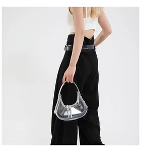 Détail du sac croissant transparent en PVC avec bordure argentée et fermoir doré