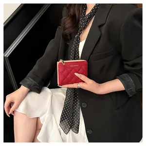 Macro view of red quilted leather wallet with gold zipper and stylish brand logo