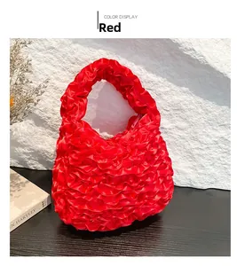 Detail of red pleated satiny ruffle handbag with elegant folds and silky texture