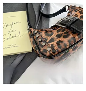 Close-up of leopard print bag with metallic rivets and glossy texture details