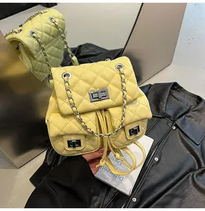Détail macro du cuir jaune matelassé et des fermoirs rotatifs en métal argenté du sac