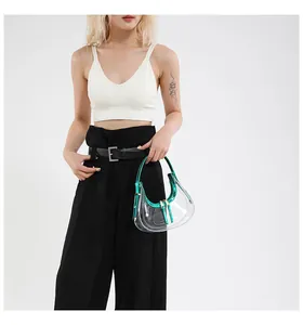 Détail d'un sac demi-lune en PVC transparent avec bordure verte métallisée et zip doré double