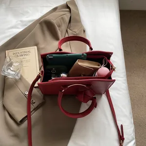 Sac fourre-tout rouge structuré avec poignées métalliques et intérieur spacieux pratique