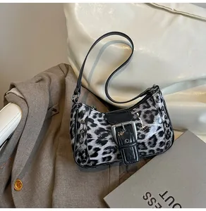 Detail of leopard print shoulder bag with silver studs and metal buckle closure