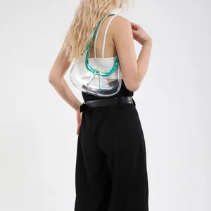 Sac bandoulière demi-lune en PVC transparent avec bordure vert métallique sur le modèle