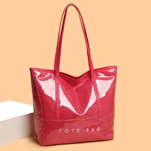 Glossy red faux leather tote bag with white lettering and long shoulder straps