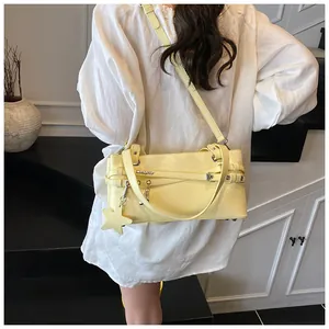 Detail of light yellow PU leather crossbody bag with star charm and metal buckle lock