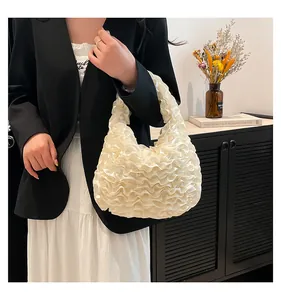 Detail of cream white pleated cloud handbag with elegant layered texture and artistic style