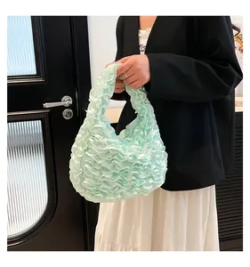 Detailansicht der hellgrünen Handtasche mit Rüschenfalten und seidiger Textur