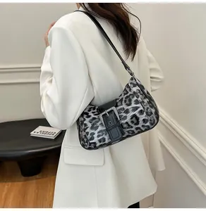 Close-up of leopard print shoulder bag with silver rivets and metal buckle detail