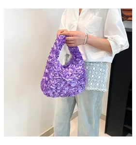 Nahaufnahme der lila Satin-Handtasche mit Rüschen kombiniert mit weißem Hemd und Jeans