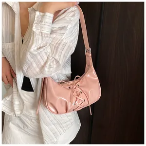 Detailed view of pink patent leather hobo bag featuring a unique lace-up design with gloss