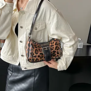 Retro leopard print shoulder bag with silver studs and glossy finish on model