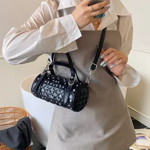 Sac cylindrique noir à la mode avec des rivets argentés et un motif matelassé