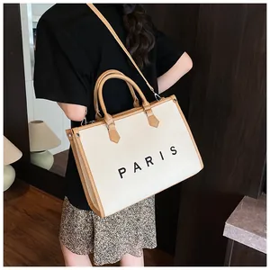 Detailed view of the large canvas tote bag with Paris print worn by a model