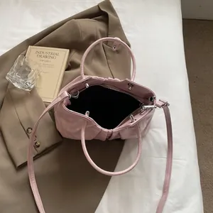 Pale pink pleated bucket handbag with silver hardware and adjustable crossbody strap