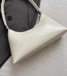 Detail der weichen PU-Lederoberfläche einer minimalistischen cremefarbenen Schultertasche