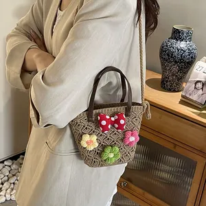 Handgewebte Strohtasche mit Strickblumen und gepunkteter Schleife in gemütlichem Heim