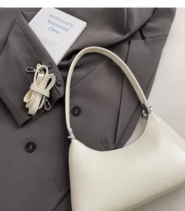 Detail der creme-farbenen PU-Umhängetasche mit verstellbarem Riemen und Metallbeschlägen