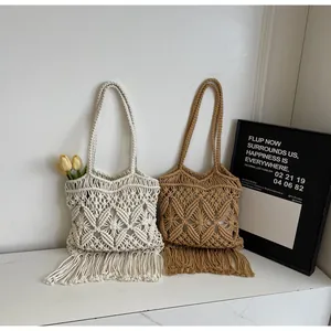 Détail d'un sac cabas en macramé avec des motifs géométriques et de longues franges en bas