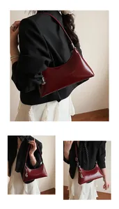 Detail of burgundy glossy faux leather shoulder bag with silver buckle and metal charm