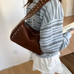 Fashionable dark brown leather underarm bag with silver rivets and metal zipper