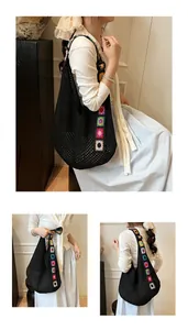 Détail du sac cabas tissé noir avec des écussons de tournesols colorés brodés