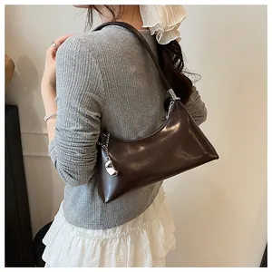 Close-up of a dark brown glossy hobo bag with a silver metal bean charm detail