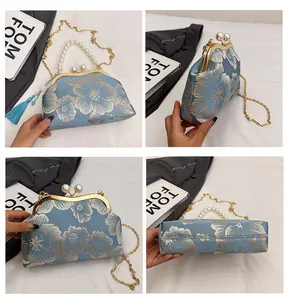 Detail view of light blue jacquard floral handbag with pearl handle and metal chain