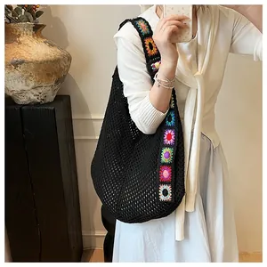 Détail d'un sac cabas en crochet noir bohème avec bretelles fleuries colorées granny square