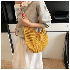 Détail du sac bandoulière en tricot jaune avec sangle au motif floral au crochet